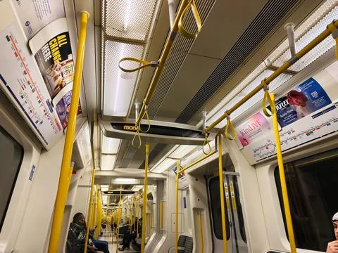 Empty London Underground train interior with yellow poles and commuters rid.. Stock Photos