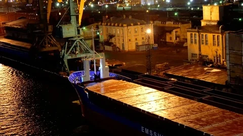 Empty long barge and ship on the dark water in the seaport with buildings under Stock Footage 73823998