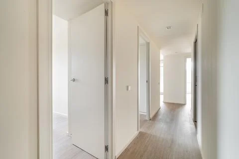 Empty long corridor with open doors to different rooms Stock Photos
