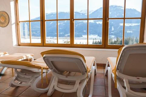 Empty lounge chairs in front of windows at luxury hotel Stock Photos