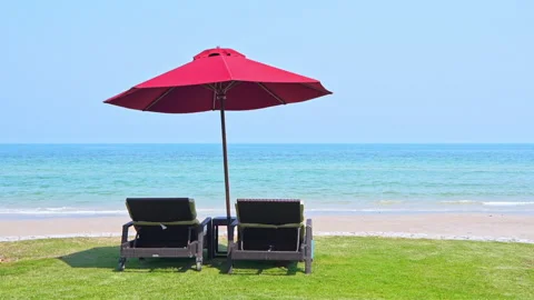 Empty Lounge Chairs in the Shadow under Parasol at the Beach Sunny Day Stock Footage 153585832