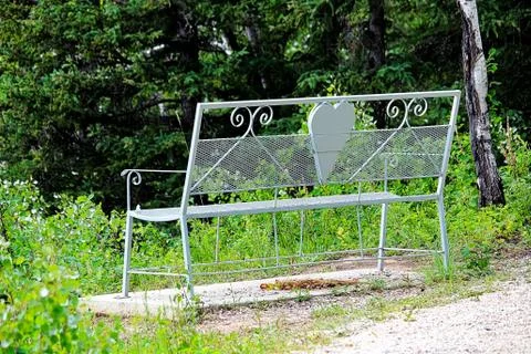 An empty lovers bench on hiking trail path Stock Photos