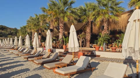 Empty Luxury Beach Resort Sunbeds and Closed Boho Umbrellas 4K Cinematic Stock Footage 338403055