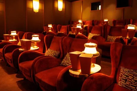 Empty luxury cinema hall with red armchairs and lamps Stock Photos