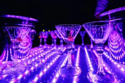 Empty Martini glasses on table with lights in the restaurant Stock Photos