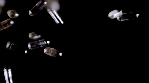 Empty medical capsules falling on black, slow motion Video stock 150329703