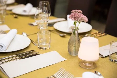 Empty menu paper beside prepared plate with flower and glasses Stock Photos