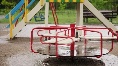 Empty merry go round carousel is wet in the rain, turns lonely in wind. a heavy Stock Footage 90873951