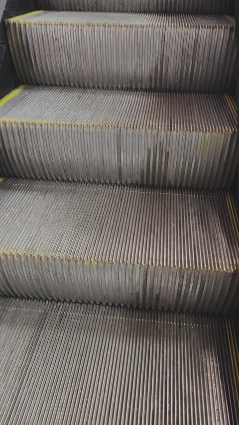 Empty metal escalator steps moving up. Abstract background of mechanical stairs Stock Footage 346182453