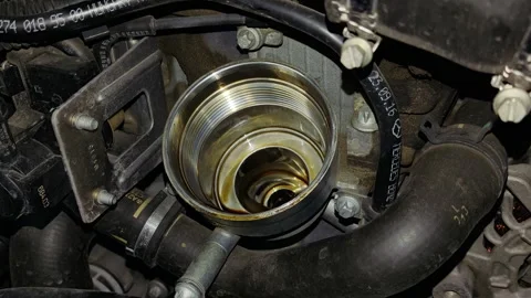 An empty metal oil filter housing inside a car engine bay. Stock Footage 343415917