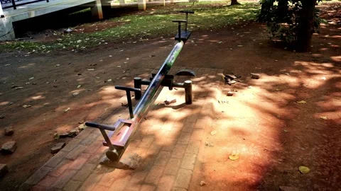 An empty metal seesaw stands in a quiet public park playground on a sunny d.. Stock Footage 342024016