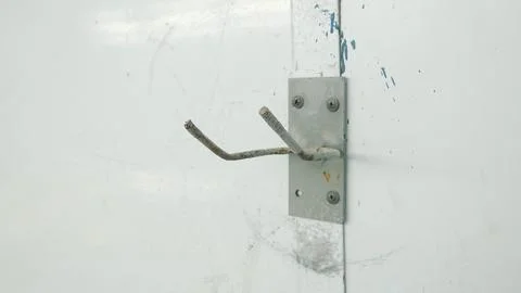 Empty Metal Wall Hook Mounted On Industrial Workshop Surface Stockfoto's