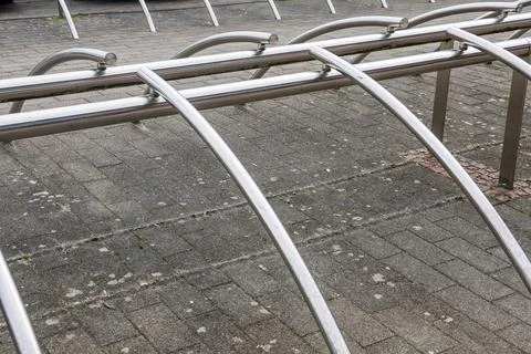 Empty metallic bicycle rack on paved surface Stock Photos
