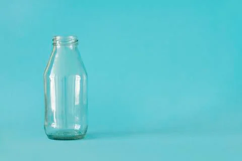 Empty milk bottle isolated on blue background, with place for text. Front view.  Stock Photos
