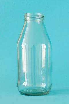Empty milk bottle isolated on blue background, front view. Close up Stock Photos