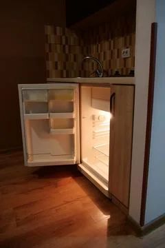 Empty mini fridge with open door in kitchen 写真素材