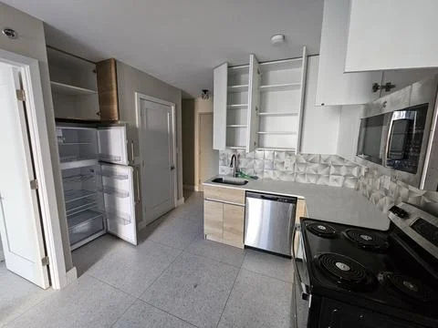 Empty modern apartment kitchen with open cabinets and stainless appliances Stock Photos