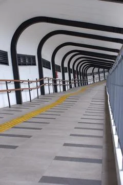 Empty Modern Bridge Corridor With Repeating Handrails and Arch Pattern Stock Photos