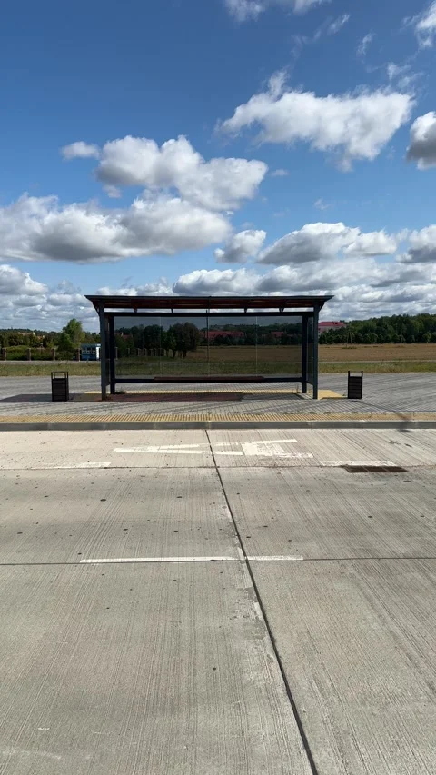 Empty modern bus shelter with glass panels on paved platform Stock Footage 345327645
