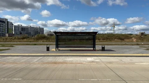 Empty modern bus stop shelter with glass panels in new development area  Video stock 343408080