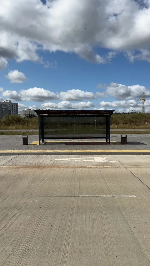 Empty modern bus stop shelter on sunny day with blue sky and clouds 스톡 동영상 344041306