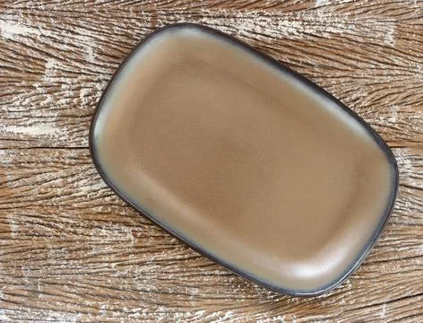 Empty modern ceramic plate on wood table background ,top view Stock Photos