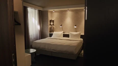 Empty Modern Hotel Room Featuring Large Bed with Warm Lighting Stock Footage 342124356