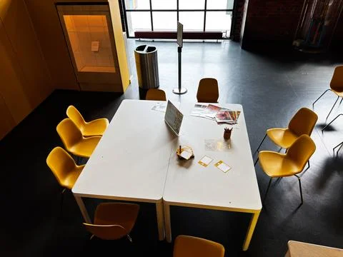 Empty modern meeting table with yellow chairs and stationery in a bright pu.. Stock Photos
