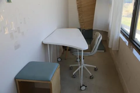 Empty modern office corner with table, chair, and stool Stock Photos