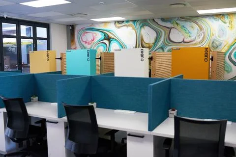 Empty modern office space with row of desks separated by desk dividers Stock Photos