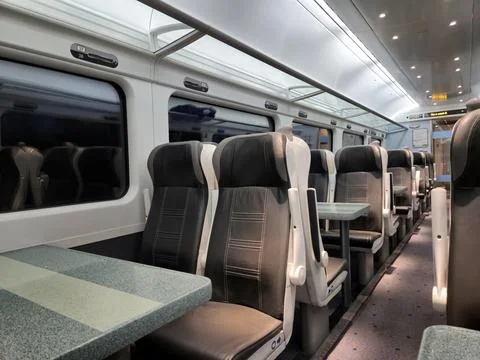Empty modern passenger train interior with seats and tables Stock Photos