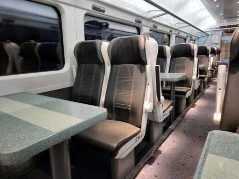 Empty modern passenger train interior with tables Stock Photos