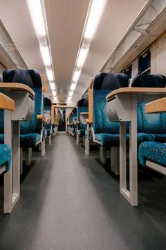 Empty modern train cabin with blue patterned seats and bright lighting, Stock Photos
