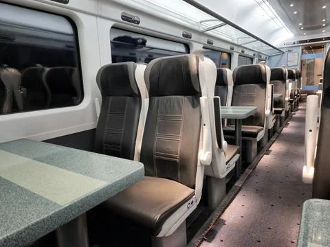 Empty modern train carriage interior with tables Stock Photos