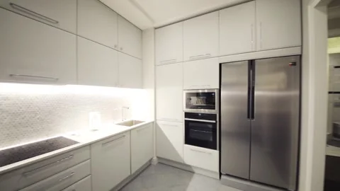 Empty modern white kitchen with built-in appliances in apartment Stock Footage 276364352