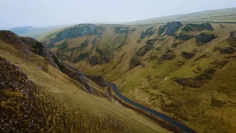 Empty mountain road in beautiful valley during winter. Scenic landscape in Peak Stock Footage 303576979