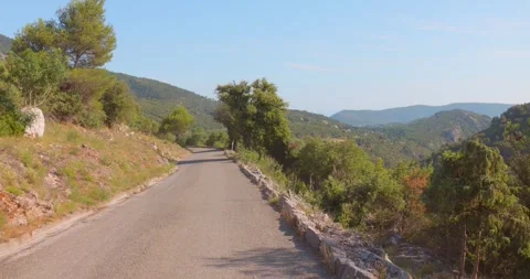 Empty Mountain Road Through Green Hills in Summer Stock Footage 345625439