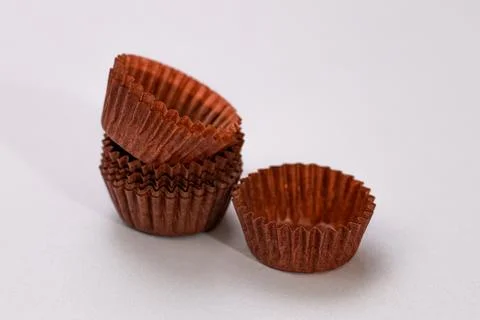 Empty muffin cake cup for baking on grey background. Stock Photos