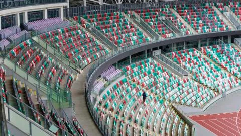 Empty multi-colored plastic seats with numbers and a piece of sports arena at Stock Photos