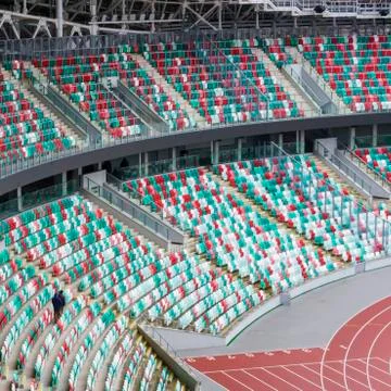 Empty multi-colored plastic seats with numbers and a piece of sports arena at Stock Photos