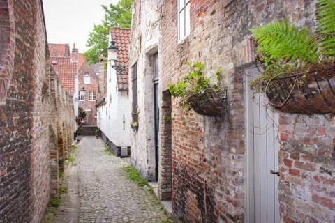 Empty Narrow Medieval Street Between Brick Houses In Bruges, Belgium Stock Photos