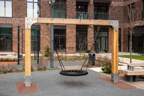 Empty nest swing with round woven seat on wooden frame with metal fittings .. Stock Photos