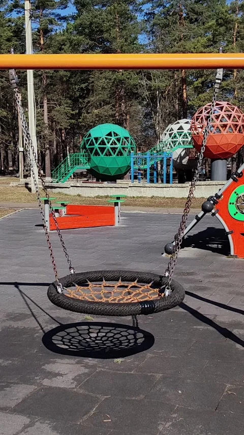 Empty nest swing swaying slowly on sunny day playground. 스톡 동영상 328968360