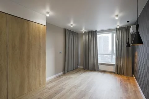 Empty new room with windows and wooden wardrobe Stock Photos