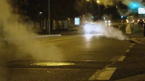 Empty night streets big megapolis city hot steam from sewer manhole yellow light Stock Footage 293715470