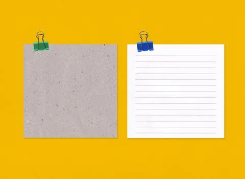 Empty note paper with clip on yellow art paper background. Stock Photos