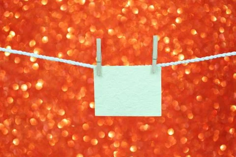 Empty note paper hang on the clothesline on red bokeh background for design i Stock Photos