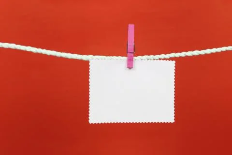 Empty note paper hang on the clothesline and have copy space with red backgro Stock Photos