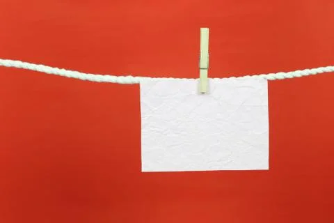 Empty note paper hang on the clothesline and have copy space with red backgro Stock Photos