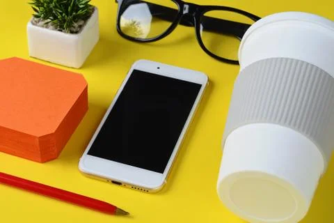 Empty note paper with plastic cup of coffee, pen, phone and glasses Stock Photos